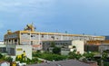 Summer industrial landscape: the blue sky and a large abandoned industrial yellow building with broken windows Royalty Free Stock Photo