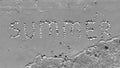 Summer inscription on the sand. The word summer laid out with shells on the sand and a sea wave. Letters made by Shells