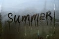 Summer inscription on the texture with condensation on the glass.