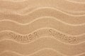 Summer inscription on the wavy sand