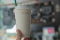 Summer interior.In the coffee shop.Blurred coffee shop background.Coffee cup in hand.Paper drink cups.Paper cups.Yellow straw. Royalty Free Stock Photo