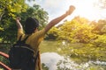 Summer journey vacations concept, Asian man traveler with backpack standing and hand up near tropical forest and looking far away