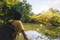 Summer journey vacations concept, Asian man traveler with backpack standing near tropical forest and looking far away