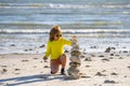 Summer kid meditation. Child with zen stones on sea beach, meditation, spa and harmony. Calm balance concept. Kids play Royalty Free Stock Photo