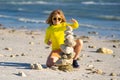 Summer kid meditation. Little kid play with pyramid stones balance on the sand of the beach. Kid with stack of stones on Royalty Free Stock Photo