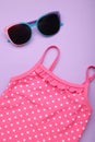 Summer kid\'s vacation concept - swimsuit with cute sunglasses on purple background. Holiday concept, fashion child Royalty Free Stock Photo