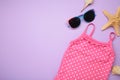 Summer kid\'s vacation concept - swimsuit with cute sunglasses on purple background. Holiday concept, fashion child Royalty Free Stock Photo