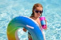Summer kids Cocktail. Happy little boy with colorful inflatable ring in outdoor swimming pool on hot summer day. Family Royalty Free Stock Photo