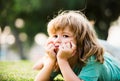 Summer kids dream outdoor portrait. Happy child enjoying on grass field and dreaming. Kids on green grass background. Royalty Free Stock Photo