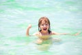 Summer kids holidays. Happy child playing in the sea. Excited kids having fun on the beach.