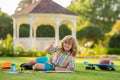 Summer kids leisure. School kid drawing in summer park, painting art. Little painter draw pictures outdoor. Happy child Royalty Free Stock Photo