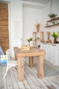 Summer kitchen interior in rustic style. Bright kitchen with a wooden table. Spring flowers and bread in a basket on the table in Royalty Free Stock Photo