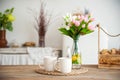 Summer kitchen interior in rustic style. Bright kitchen with a wooden table. Spring flowers and bread in a basket on the table in Royalty Free Stock Photo