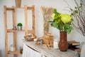 Summer kitchen interior in rustic style. Bright kitchen with a wooden table. Spring flowers and bread in a basket on the table in Royalty Free Stock Photo