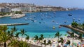 Summer landscape with a beach with people bathing, hotels and boats anchored in the sea. Gran Canaria. Arguineguin. Spain Royalty Free Stock Photo