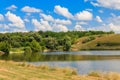 Summer landscape with beautiful lake, green meadows, hills, trees and blue sky Royalty Free Stock Photo