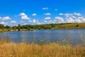 Summer landscape with beautiful lake, green meadows, hills, trees and blue sky Royalty Free Stock Photo