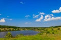 Summer landscape with beautiful lake, green meadows, hills, trees and blue sky Royalty Free Stock Photo