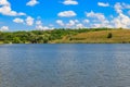 Summer landscape with beautiful lake, green meadows, hills, trees and blue sky Royalty Free Stock Photo