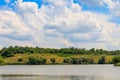 Summer landscape with beautiful lake, green meadows, hills, trees and blue sky Royalty Free Stock Photo