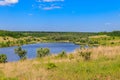 Summer landscape with beautiful lake, green meadows, hills, trees and blue sky Royalty Free Stock Photo