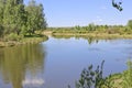 Summer landscape - A calm flat river among fields and birch groves under a blue sky. Cloudless summer weather Royalty Free Stock Photo