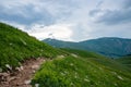 Summer landscape on a cloudy day in the mountains with a trail. Russia, Adygea