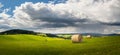 summer landscape with a field with hay bales and blue sky with white clouds Royalty Free Stock Photo