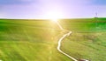 Summer landscape with green grass, roads and clouds, field dirt road in summer