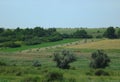 Summer landscape with haystacks on the slope. Royalty Free Stock Photo