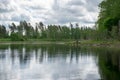 Summer landscape with lake and white cloud reflections in the water, tree silhouettes reflect in the lake water Royalty Free Stock Photo