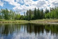 Summer landscape with lake and white cloud reflections in the water, tree silhouettes reflect in the lake water Royalty Free Stock Photo