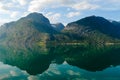 Summer landscape with mountains and sky reflecting in the fjord in rural Norway. Royalty Free Stock Photo