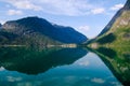 Summer landscape with mountains and sky reflecting in the fjord in rural Norway. Royalty Free Stock Photo