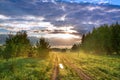 Summer landscape with road, a meadow,forest and fog. Royalty Free Stock Photo