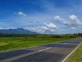 Summer landscape with road through rural land. Tropical nature bright view from highway Royalty Free Stock Photo