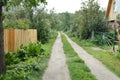 Summer landscape of a rural road along the fence and village houses, Russia, Western Siberia Royalty Free Stock Photo