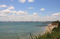 Summer landscape of the sea and green grass. Sandy beach and blue water with sky and white clouds. Sunny beach in Bulgaria on the