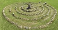 Summer landscape with a stone labyrinth on a green lawn