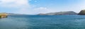 Summer landscape. Turquoise water, blue sky and mountains in the haze. Strait of Olkhon Gate. Lake Baikal, Siberia, Russia.