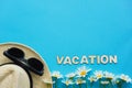 Summer layout with straw hat, daisies and sunglasses and inscription Vacation. Concept of travel and recreation. Flights to sea,