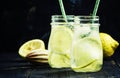 Summer lemonade with soda and ice in glass bottles, dark background, selective focus