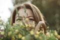 Summer lifestyle portrait of beautiful young woman smiling and holding bouquet of wild flowers. Standing in the field of grass. Royalty Free Stock Photo