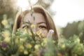 Summer lifestyle portrait of beautiful young woman smiling and holding bouquet of wild flowers. Standing in the field of grass. Royalty Free Stock Photo