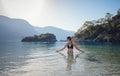 Happy traveller woman in black swimsuit enjoys her tropical beach vacation Royalty Free Stock Photo