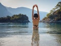 Happy traveller woman in black swimsuit enjoys her tropical beach vacation Royalty Free Stock Photo