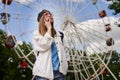 Summer lifestyle portrait woman enjoy nice day, talking smartphone. Happy female in front of ferris wheel. Young girl Royalty Free Stock Photo