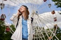 Summer lifestyle portrait woman enjoy nice day, talking smartphone. Happy female in front of ferris wheel. Young girl Royalty Free Stock Photo