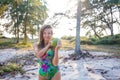 Young beautiful woman holding coconut and standing near palms Royalty Free Stock Photo