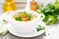 Summer light vegetarian vegetable soup with carrot, potato, cabbage and grean peas on white background. Diet healthy and tasty lun Royalty Free Stock Photo